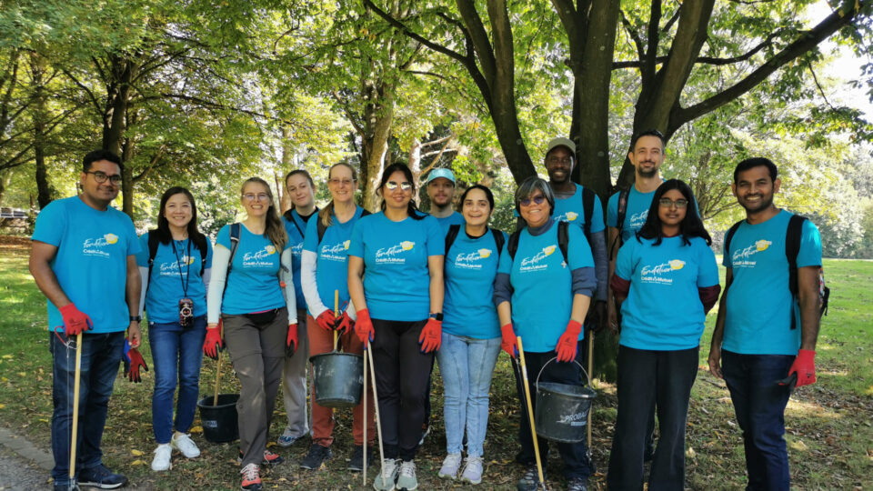 Das IT Team der TARGOBANK steht im Duisburger Biegerpark und hält Utensilien zum Müll aufräumen in den Händen.