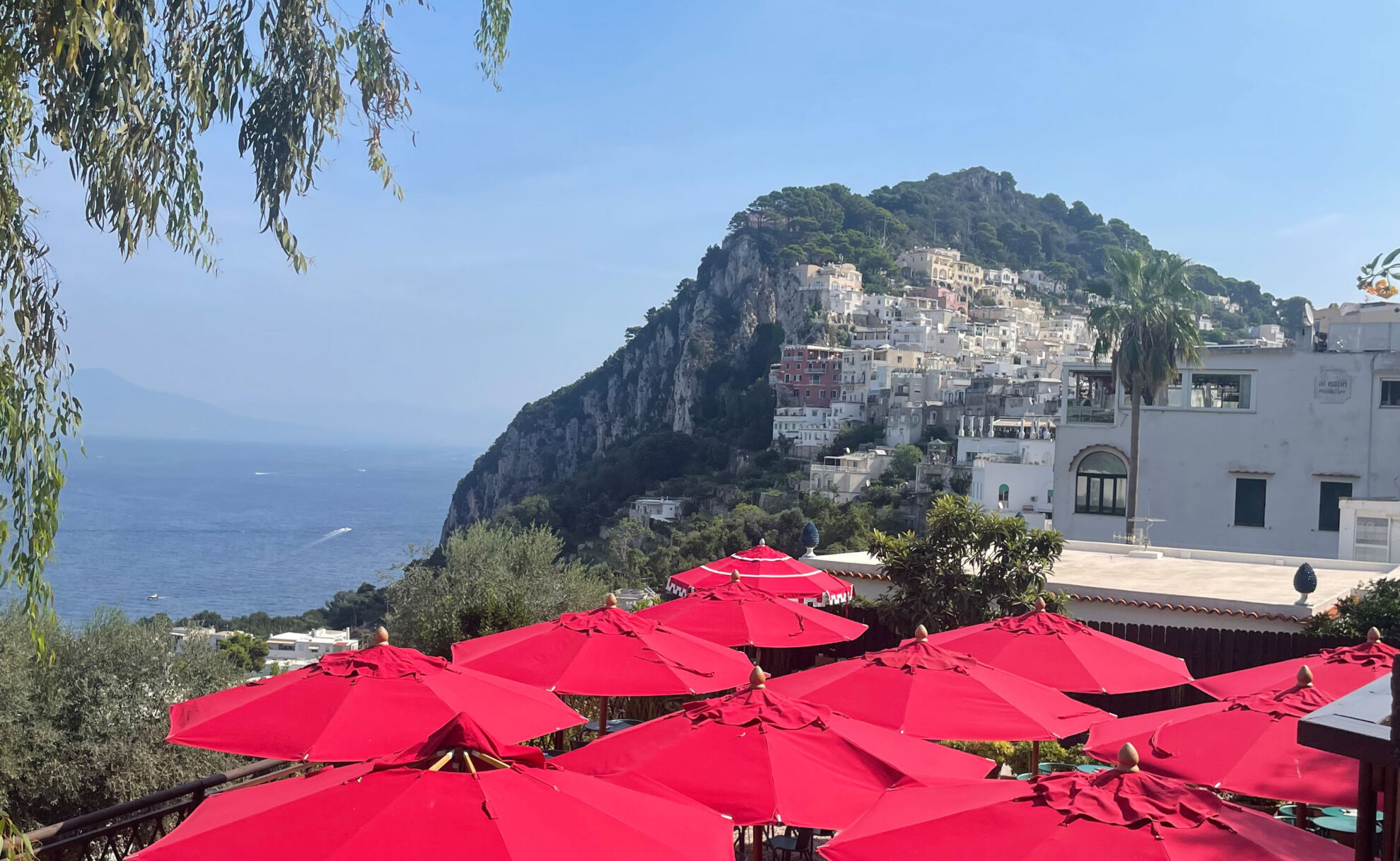 Rote Schirme eines Restaurants und Blick auf das Meer