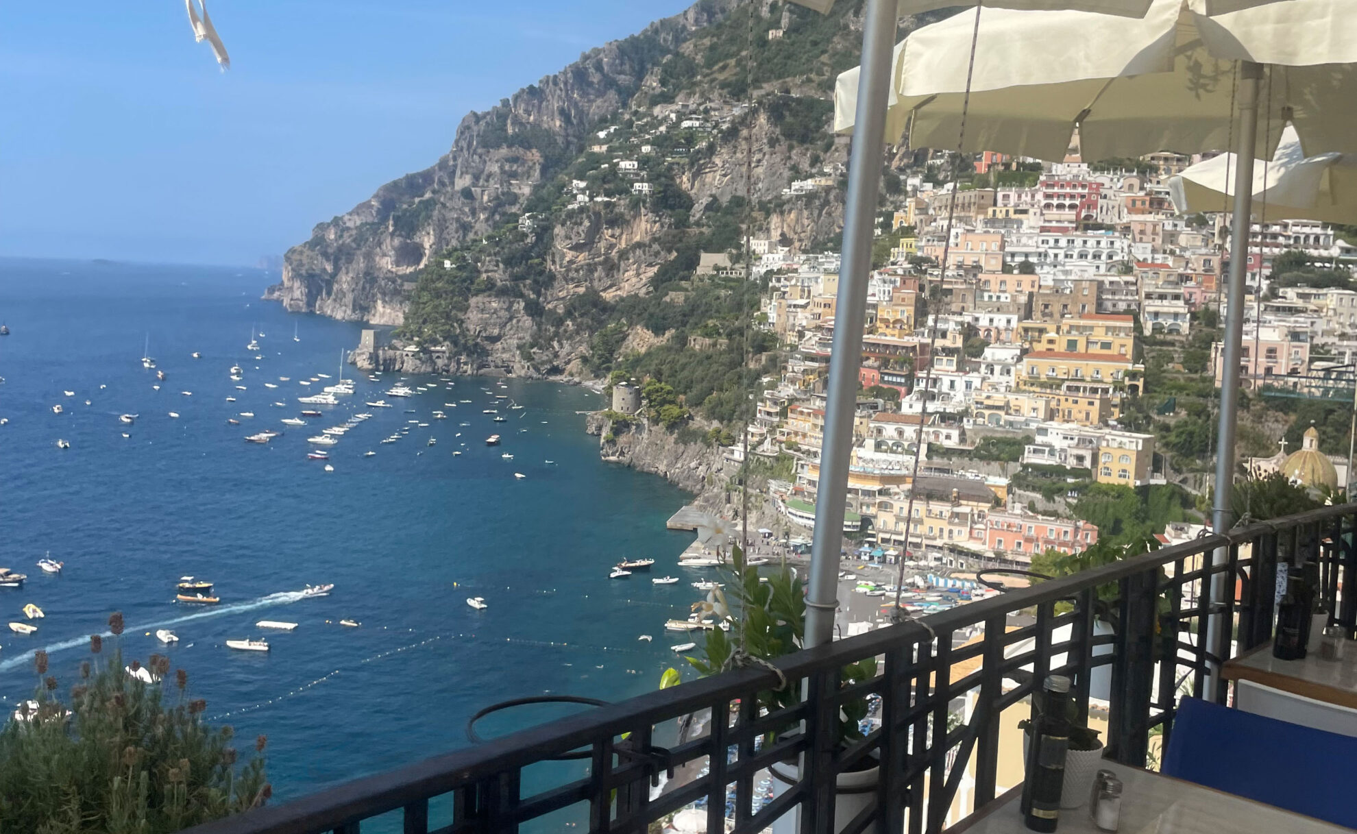 Blick von einem Restaurant auf das Meer und die Häuser im Berg von Positano