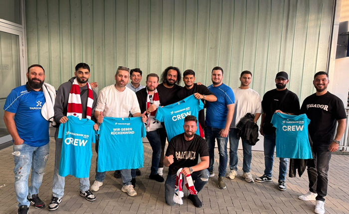 Die Spieler der TARGOBANK Fußballmannschaft machen ein Gruppenbild und zeigen dabei das TARGOBANK Crew Shirt.