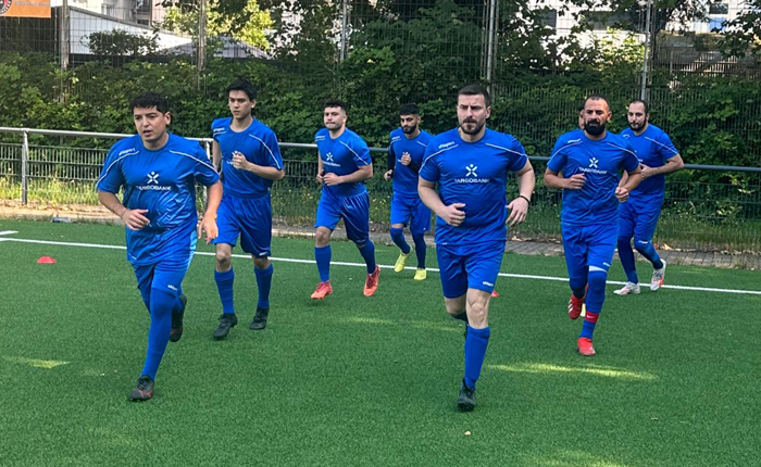 Die Spieler der TARGOBANK Fußballmannschaft laufen bei einem Fußballspiel auf das Feld ein.