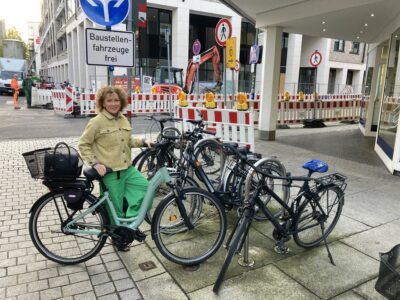 Nelly mit ihrem Fahrrad vor dem Fahrradständer in der Innenstadt vor der TARGOBANK Filiale Osnabrück