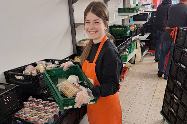 Hannah Wieber trägt eine Kiste mit Lebensmitteln in den Räumlichkeiten der Tafel Northeim.