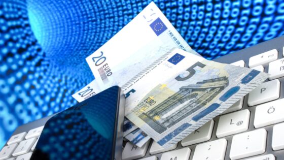 Handy und Geld auf einer Tastatur im Netz