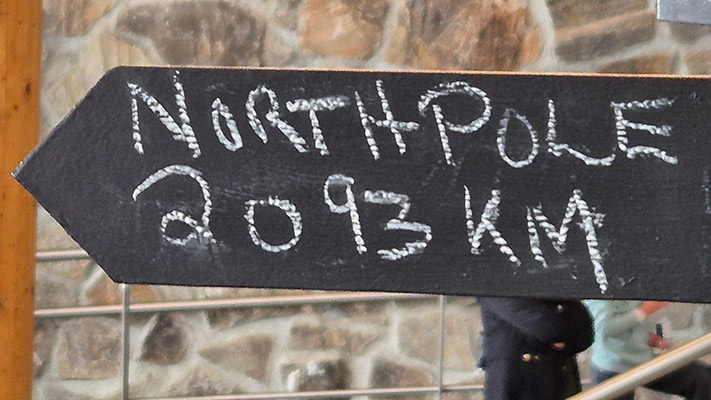 Ein schwarzes Schild zeigt in Richtung Nordpol mit der Aufschrift 