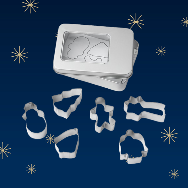 Eine silberne Dose mit einem transparenten Deckel, die verschiedene Ausstechformen in verschiedenen Formen zeigt, darunter ein Schneemann, ein Weihnachtsbaum und eine Figur. Der Hintergrund ist dunkelblau mit goldenen Sternen.
