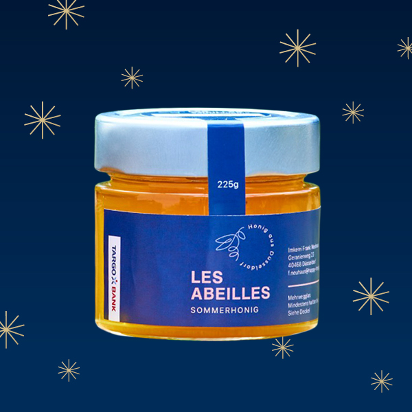 Ein Glas Honig mit der Aufschrift 'LES ABEILLES SOMMERHONIG' und dem Gewicht von 225g auf einem dunklen Hintergrund mit Sternen.