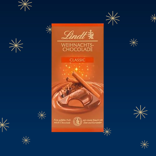 Eine Lindt Weihnachts-Schokolade mit einem klassischen Design, umgeben von einem blauen Hintergrund und goldenen Sternen.