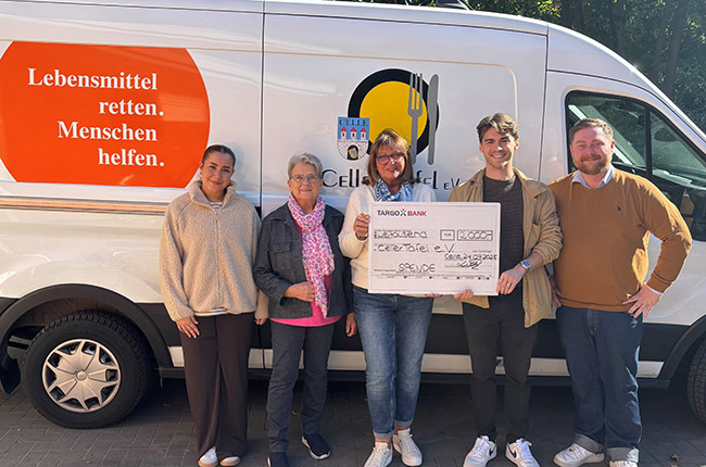 Fünf Personen stehen vor einem Lieferwagen mit dem Logo "Lebensmittel retten. Menschen helfen." Sie halten einen großen Scheck von der TARGOBANK, der auf die Organisation "Cellertafel e.V." ausgestellt ist. Die Personen tragen legere Kleidung und lächeln.