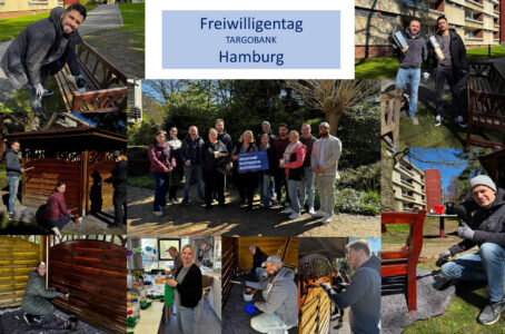 Das Bild zeigt eine Gruppe von Freiwilligen von TARGOBANK in Hamburg, die an einem Freiwilligentag teilnehmen. Die Teilnehmer stehen und arbeiten in einem Garten, mit Bänken und Holzkonstruktionen, die sie streichen und renovieren. Einige Personen halten Pinsel und Farbe, während andere in Gruppen posieren. Ein Banner mit der Aufschrift "Freiwilligentag TARGOBANK Hamburg" ist prominent in der Mitte zu sehen. Die Atmosphäre ist sonnig und freundlich.